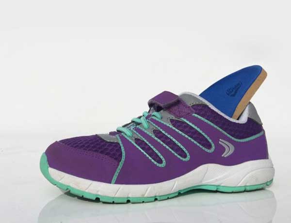 Custom-made orthotic insole fitted inside a child’s trainer for foot alignment and stability